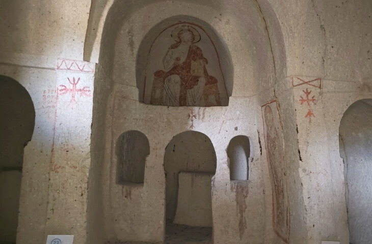 Göreme Açık Hava Müzesi’ndeki Pantokrator Kilisesi’nin iç mekanı; kaya oyma mimari, apsiste oturur pozisyonda Pantokrator figürü ve kırmızı haç motifleriyle görülüyor.